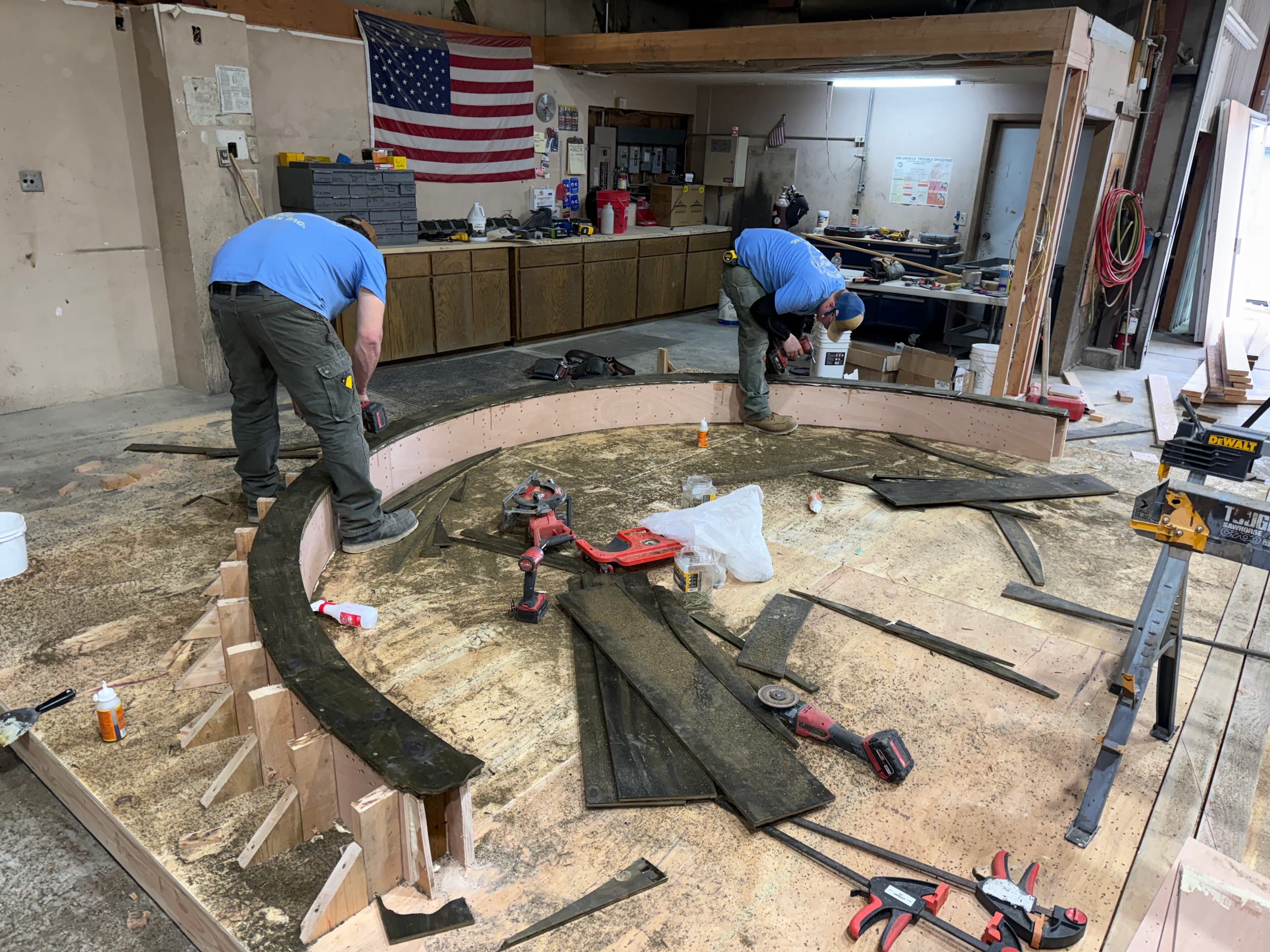 Dynamic Decks crew shaping a curved deck border in the workshop