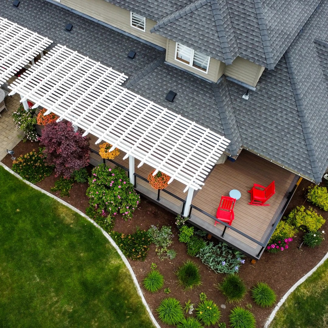 Deck with black cable rail and white pergola.