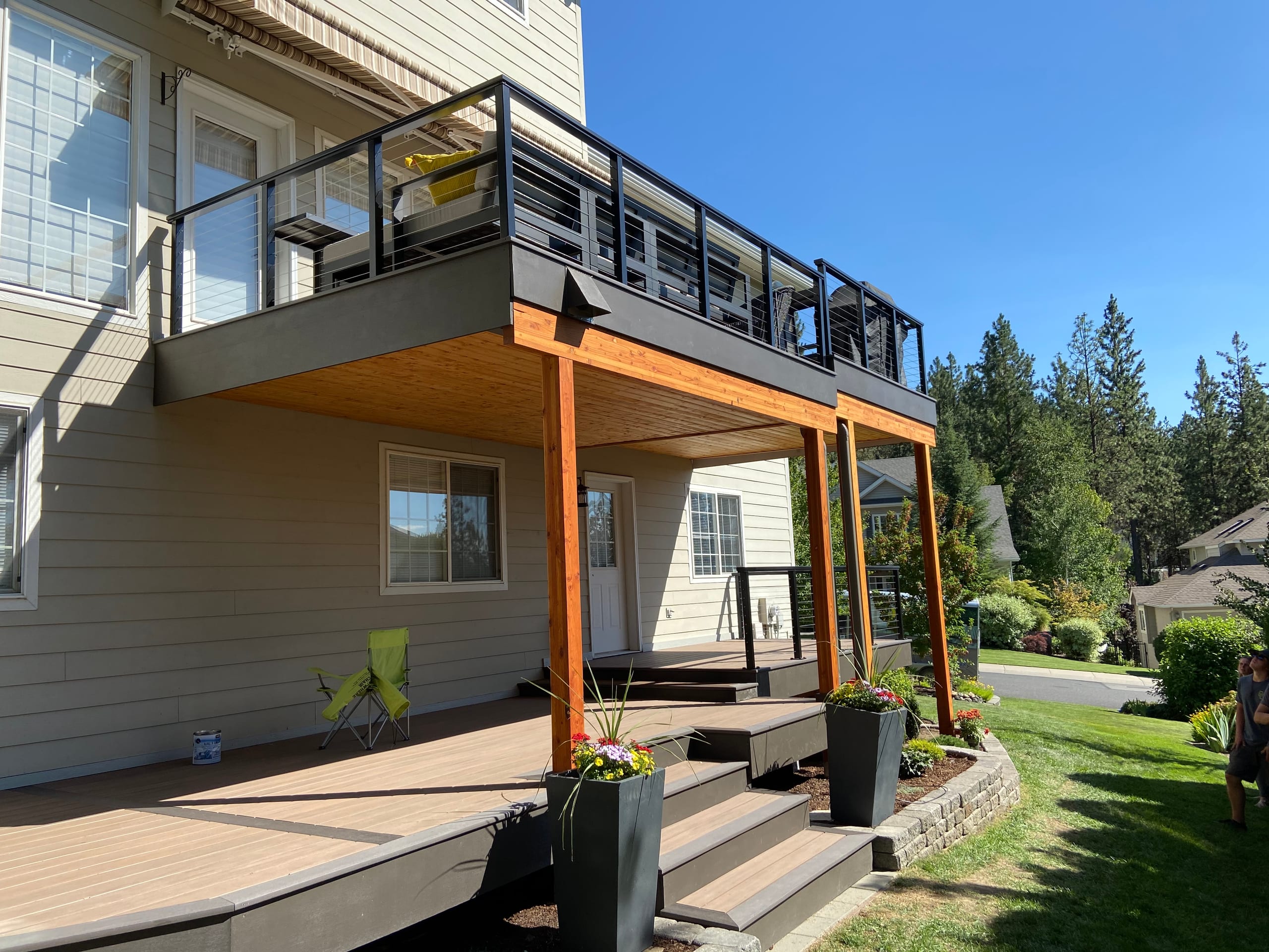 Elevated grey composite deck with black cable-style railing