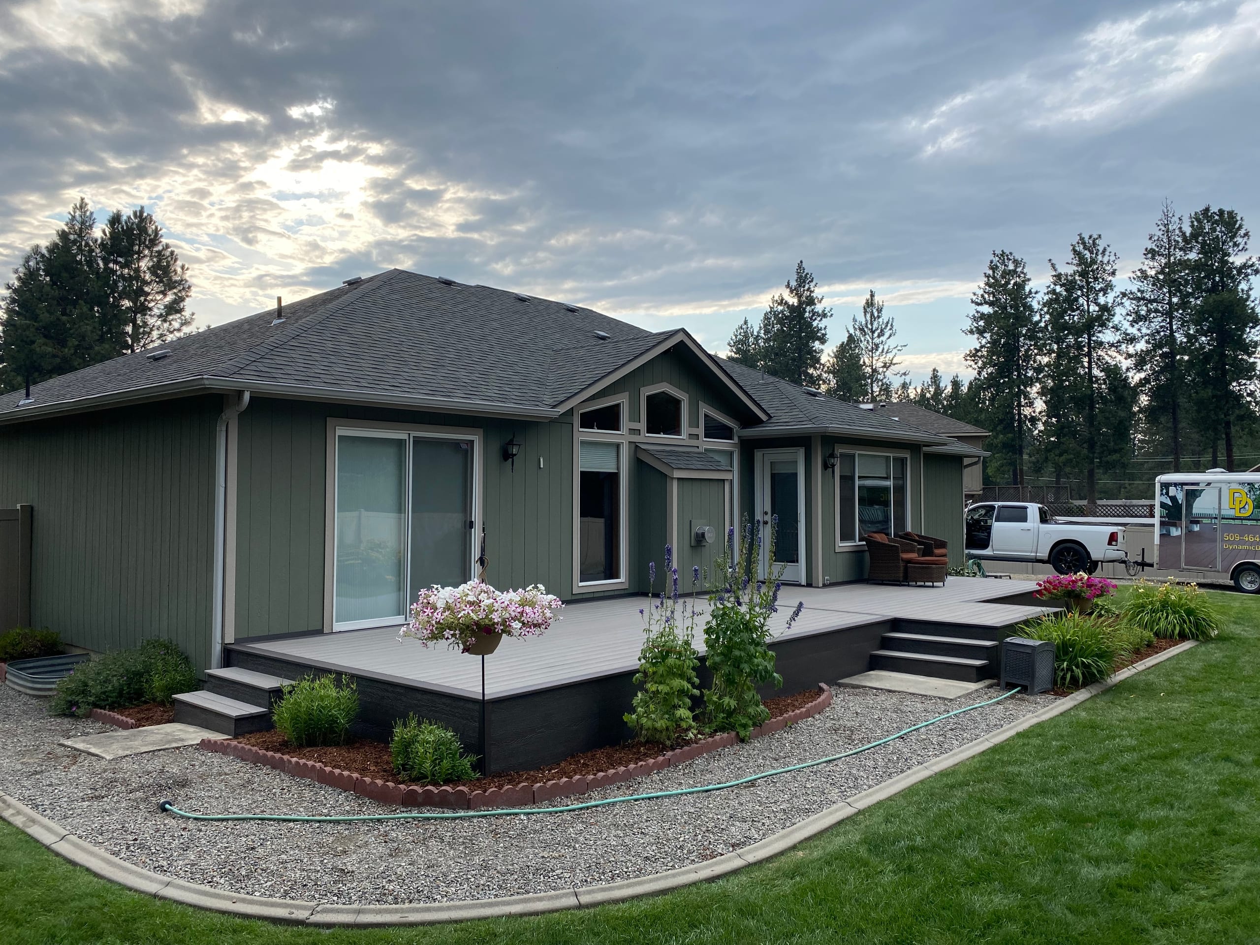 Low gray deck with dark skirting and steps wrapping the back of a single-story house
