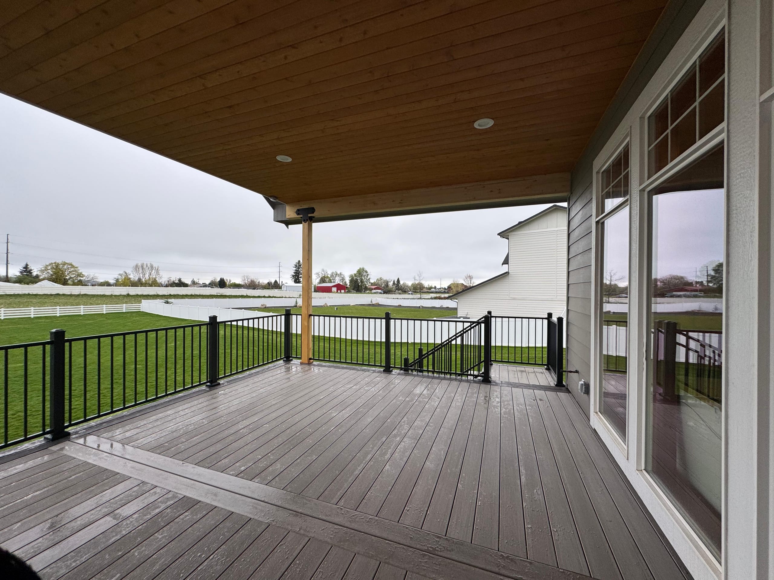 Wide covered deck with stained wood ceiling, can lights